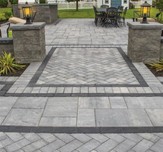 Cambridge-Sherwood LEDGESTONE 4 1/2 X 9 SMOOTH, border is coal color inlaid into patio composed with an assortment of other kits